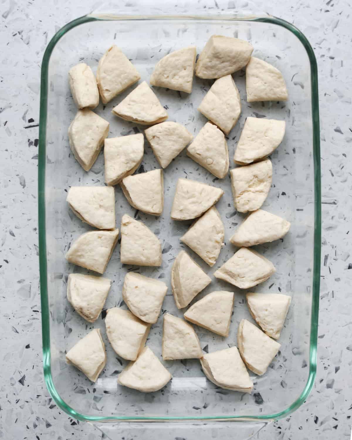 pieces of uncooked biscuits in a glass pan